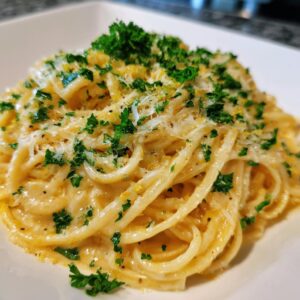 A plate of Creamy Lemon Pasta, garnished with fresh parsley and parmesan cheese.