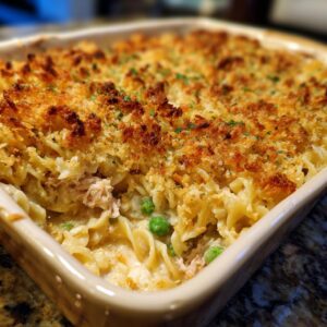 Close-up of creamy Tuna Casserole with noodles, peas, tuna, and a golden brown breadcrumb topping.