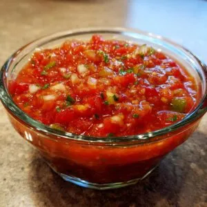 Close-up of a bowl of vibrant, fresh homemade salsa with tomatoes, onions, and cilantro.