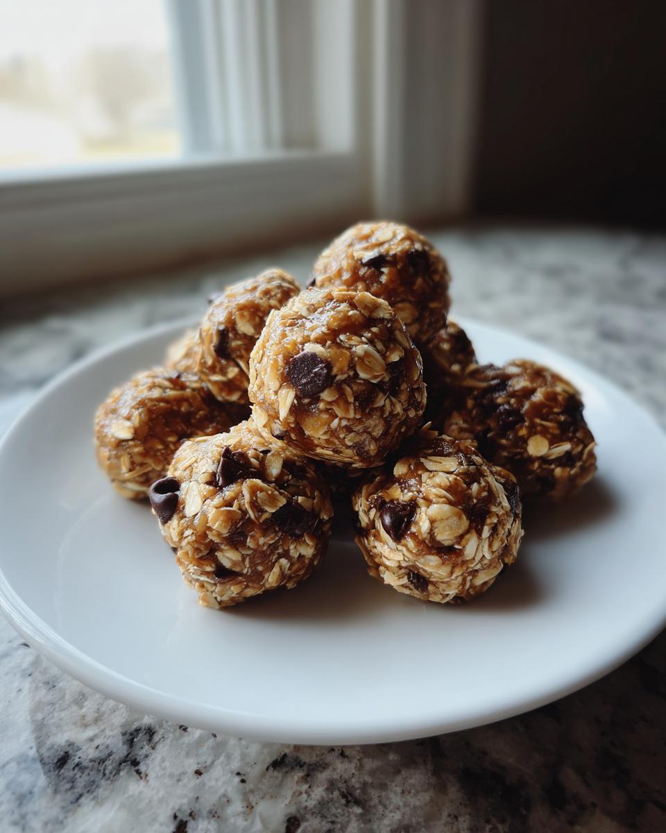 A stack of homemade no-bake energy bites on a white plate, featuring oats and chocolate chips.