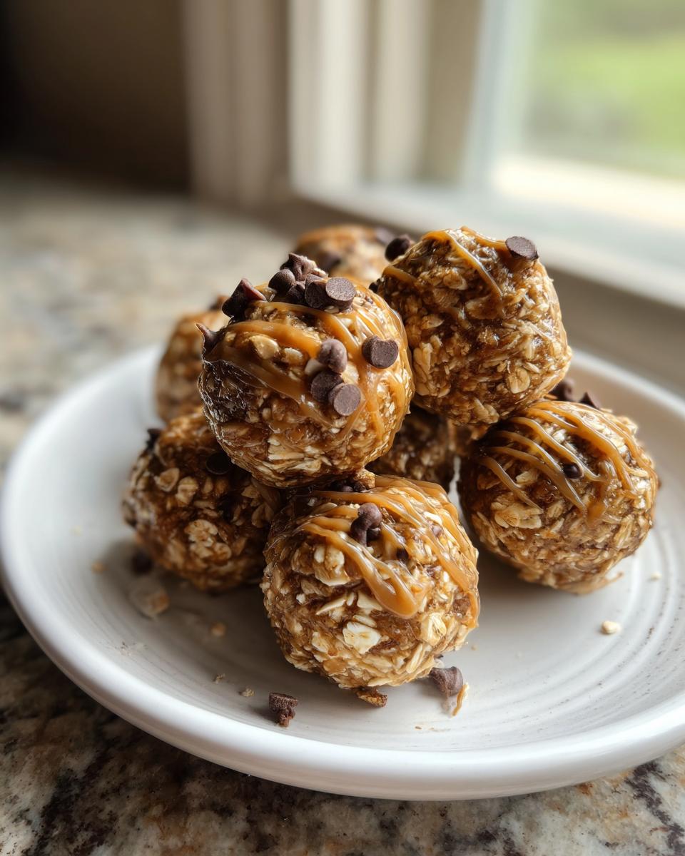 A stack of no-bake energy bites topped with chocolate chips and caramel drizzle on a white plate.