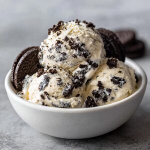 A bowl of creamy no-churn Oreo ice cream with cookie pieces and whole cookies.