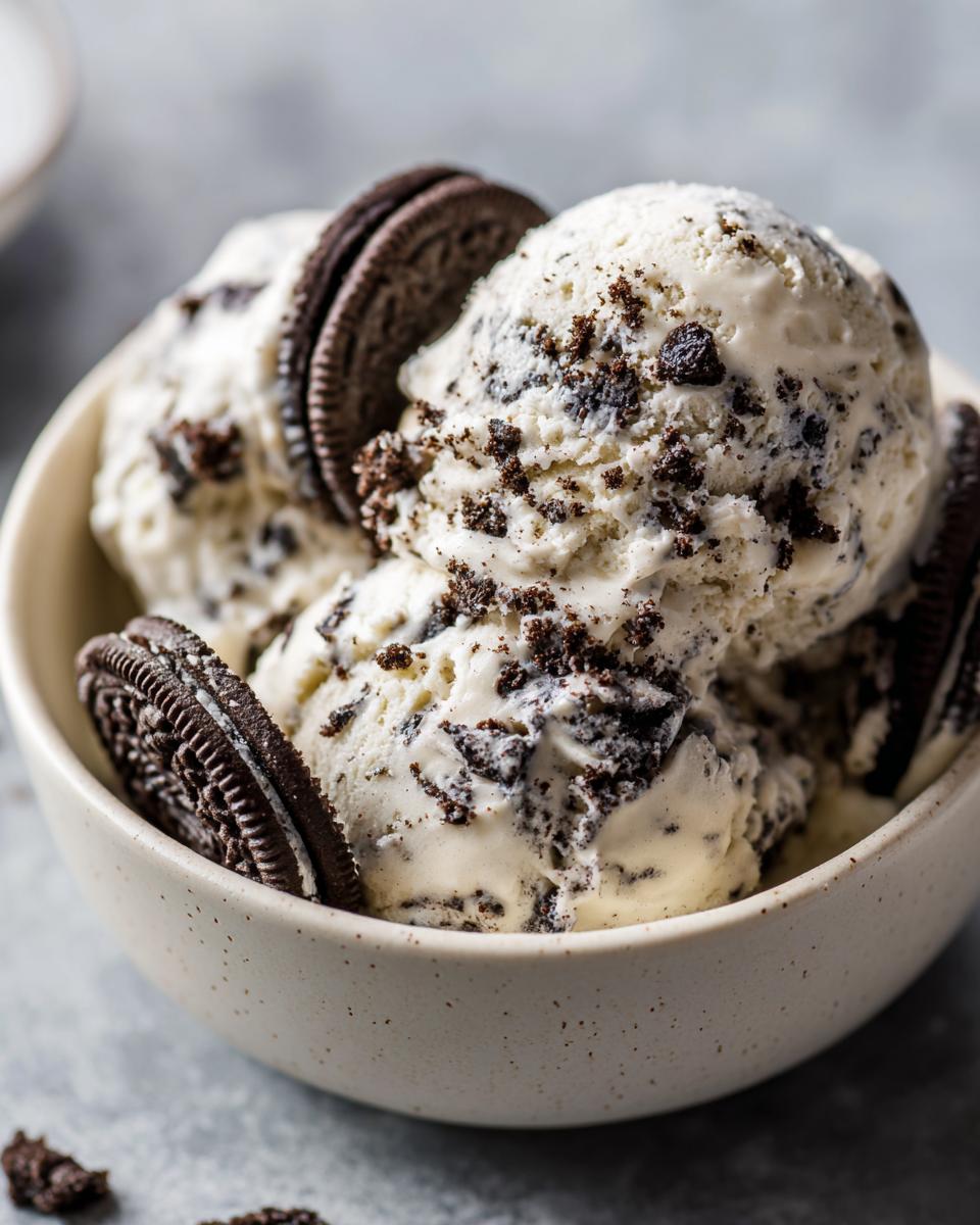 A bowl of creamy no-churn Oreo ice cream, topped with Oreo cookies and crumbs.