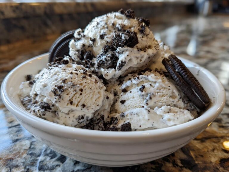 A bowl of creamy no-churn Oreo ice cream, topped with crushed Oreos and whole cookies.