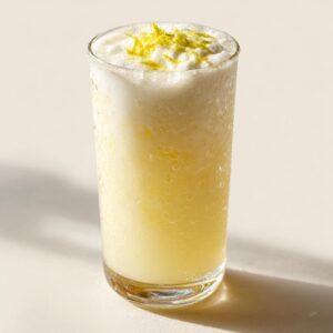 A glass of creamy whipped lemonade topped with lemon zest, ready to enjoy.